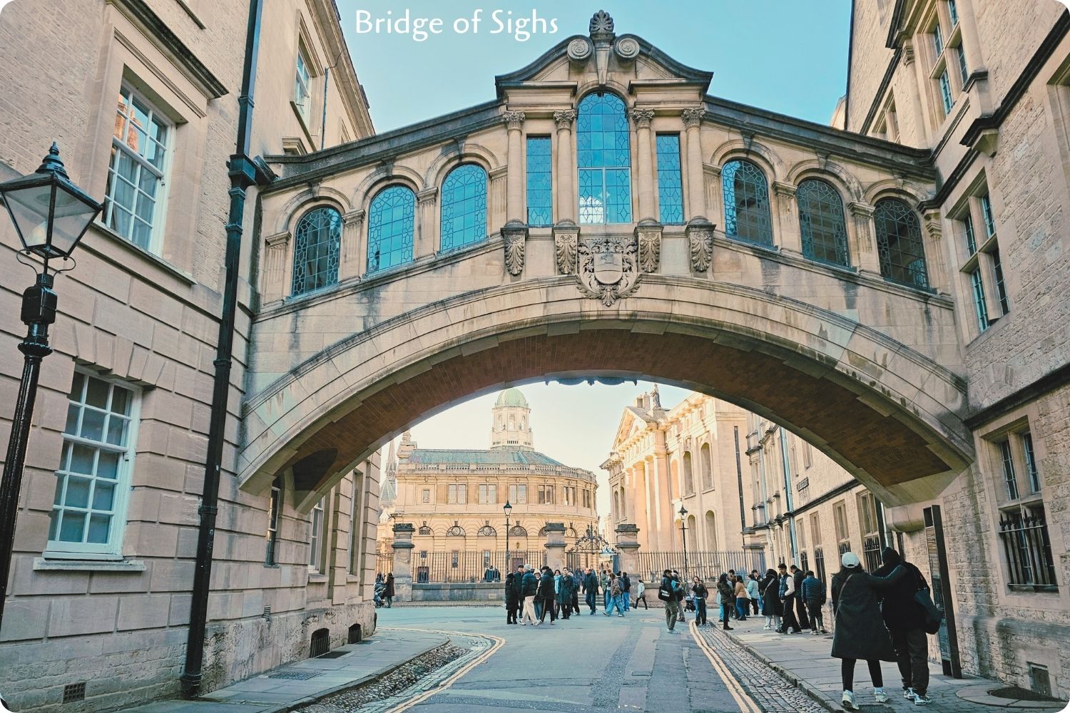 Bridge of Sighs in Oxford, an iconic arched structure with intricate stonework and glass windows, connecting two historic university buildings.