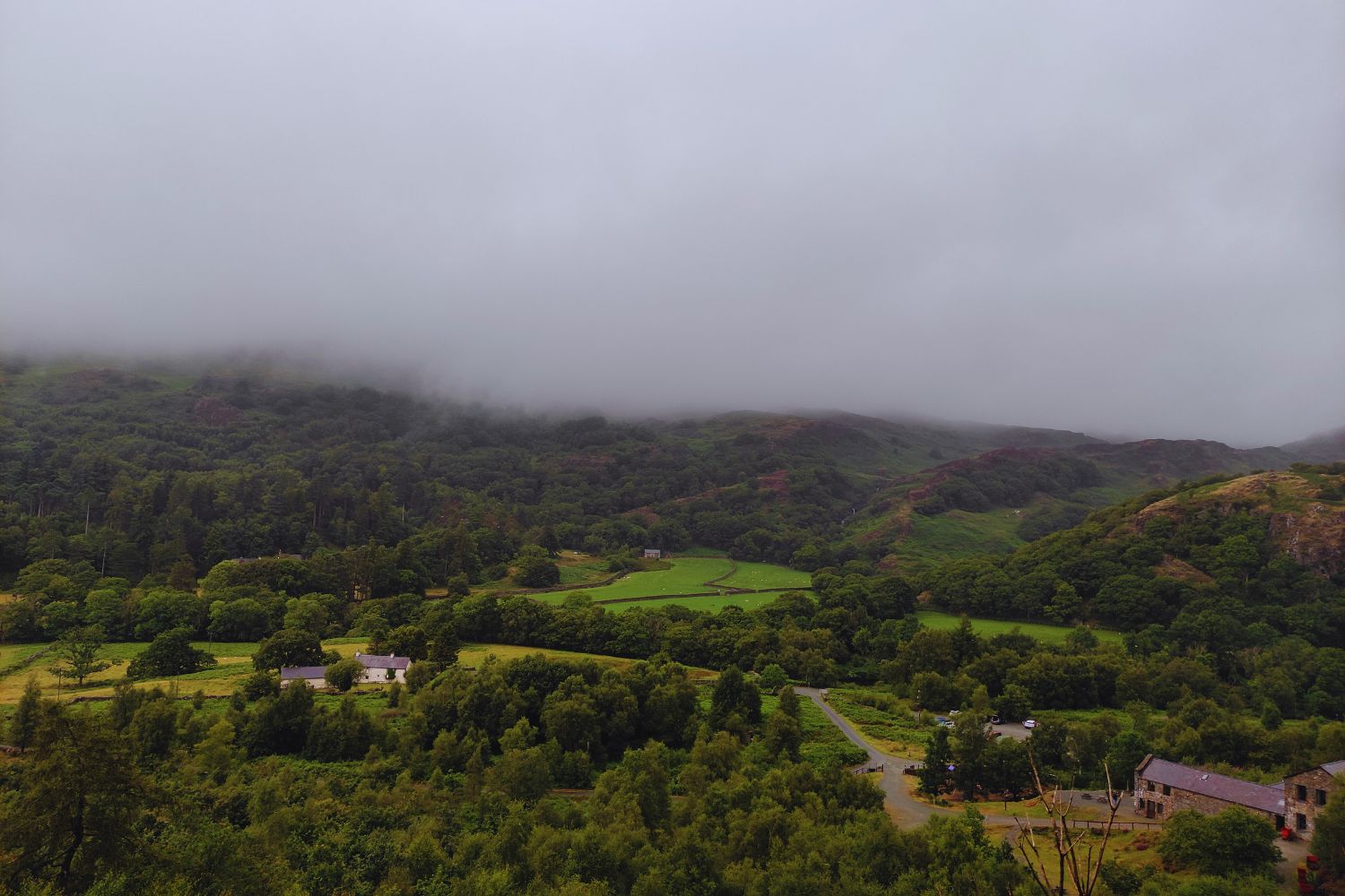 Panoramic view of the valley from the exit of the Sygun Copper Mines, with lush green landscapes and rolling hills stretching into the distance, offering a serene contrast to the underground world just explored.