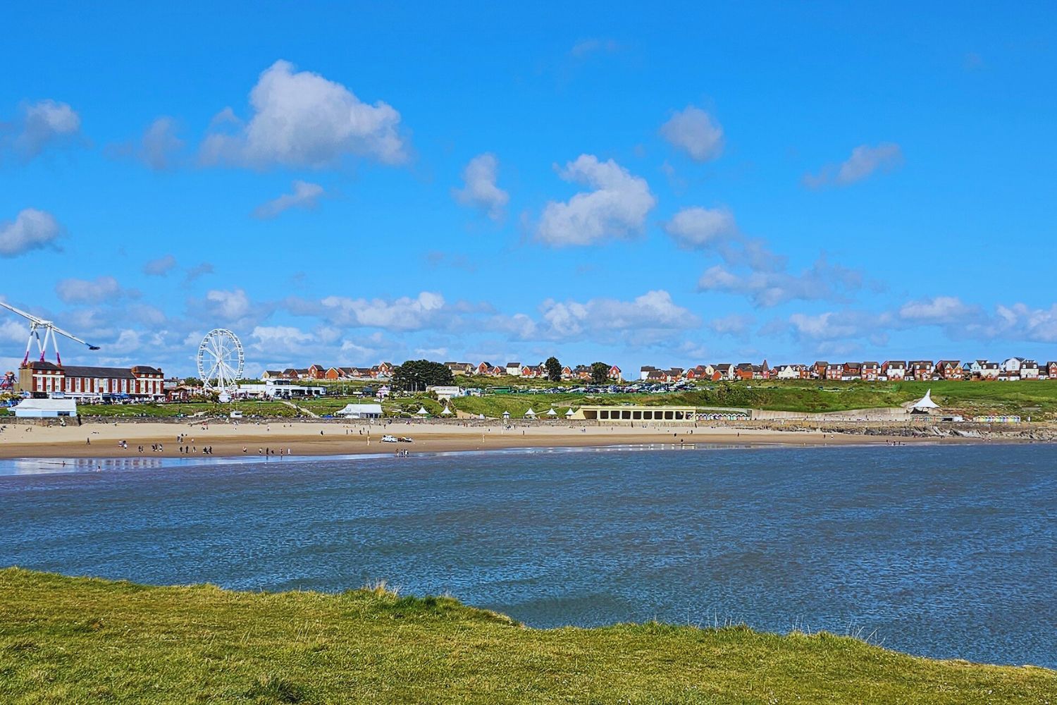 Sweeping view of Whitmore Bay from Friars Point, with golden sand, blue waters, and beach activity visible in the distance.