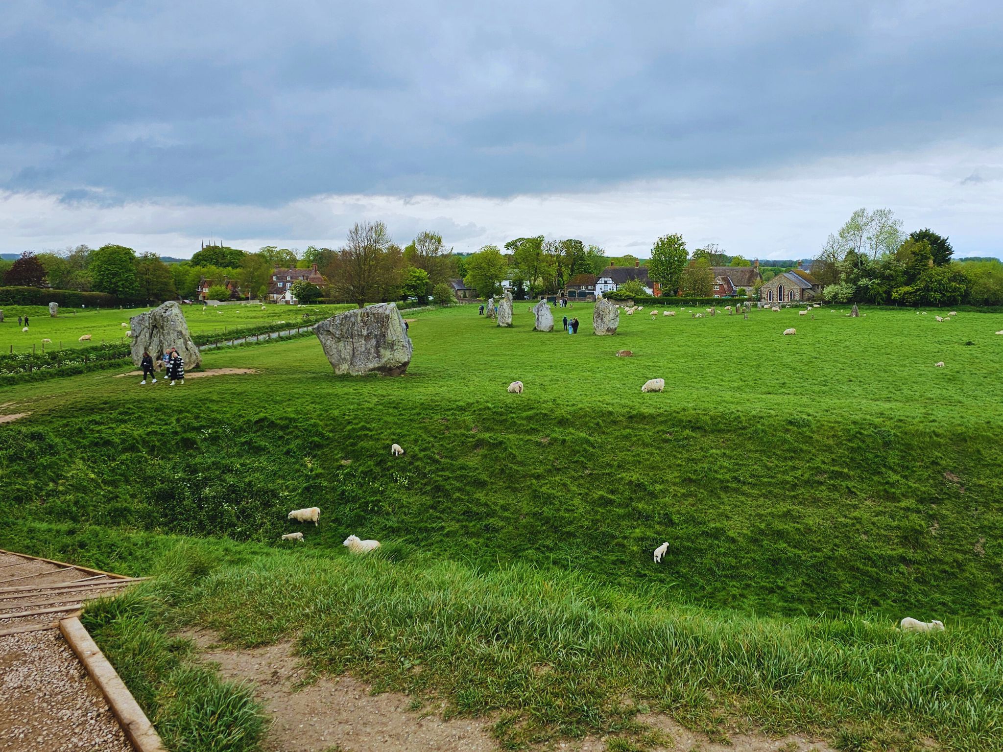 Small standing stones at Avebury surrounded by wide green fields and open countryside.